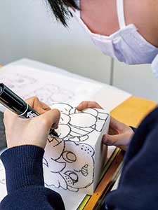 下描きができた生徒は立方体にカーボン紙で写し、ペンでなぞっていく。様々な材料を扱うことが同校美術の特徴