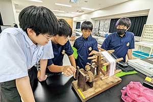 理科と社会のクロスカリキュラムでは、カイコから絹糸をつくり、日本の歴史における生糸産業の重要性を学ぶ