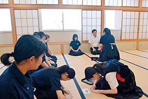 大きな和室で、お辞儀などの茶道の基本的な礼儀作法を学ぶ